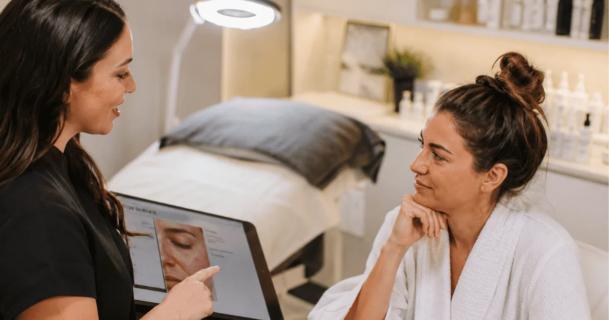 Esthetician providing a personalized skin consultation before a custom facial treatment in a modern spa